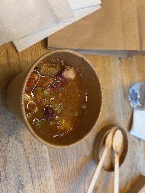 Red soup with chunky vegetables and beans.