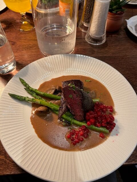 medium reindeer steak with lingonberry sauce and asparagus