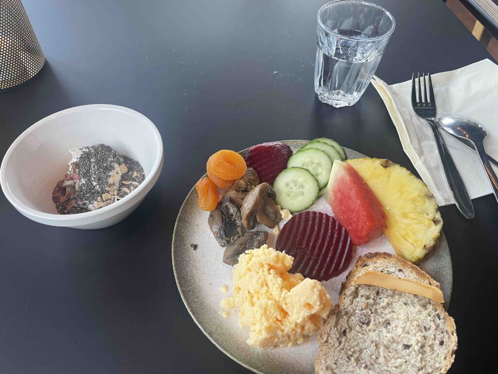 Hotel breakfast with yogurt, eggs, various fruit and vegetables and fresh bread
