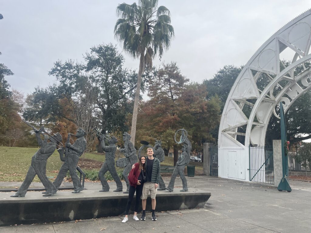 woman and man in front of walking statues in New Orleans