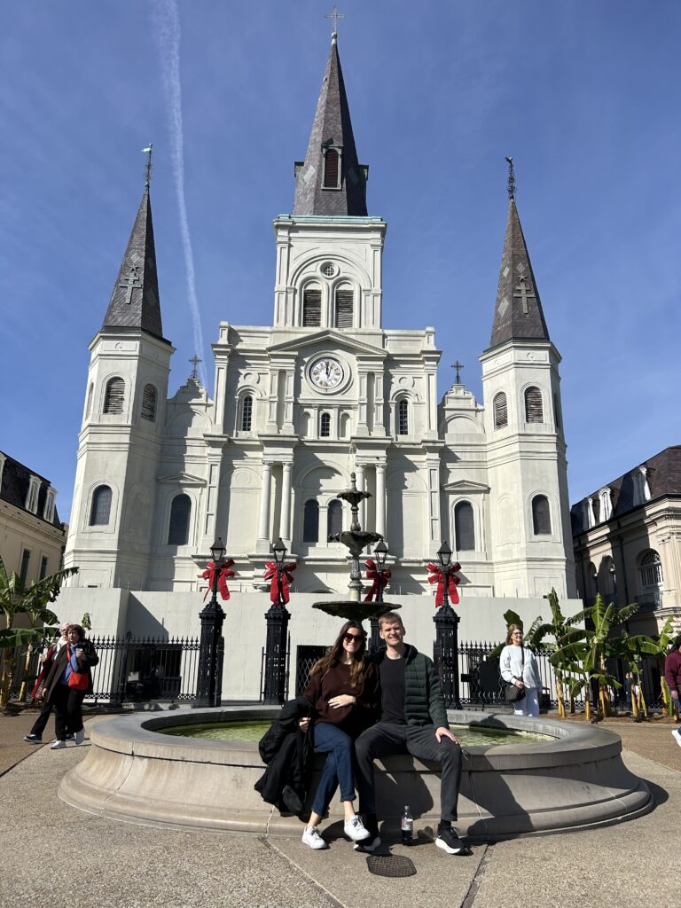 couple sitting in front of St. Louis Cathedral in Jackson Square in New Orleans